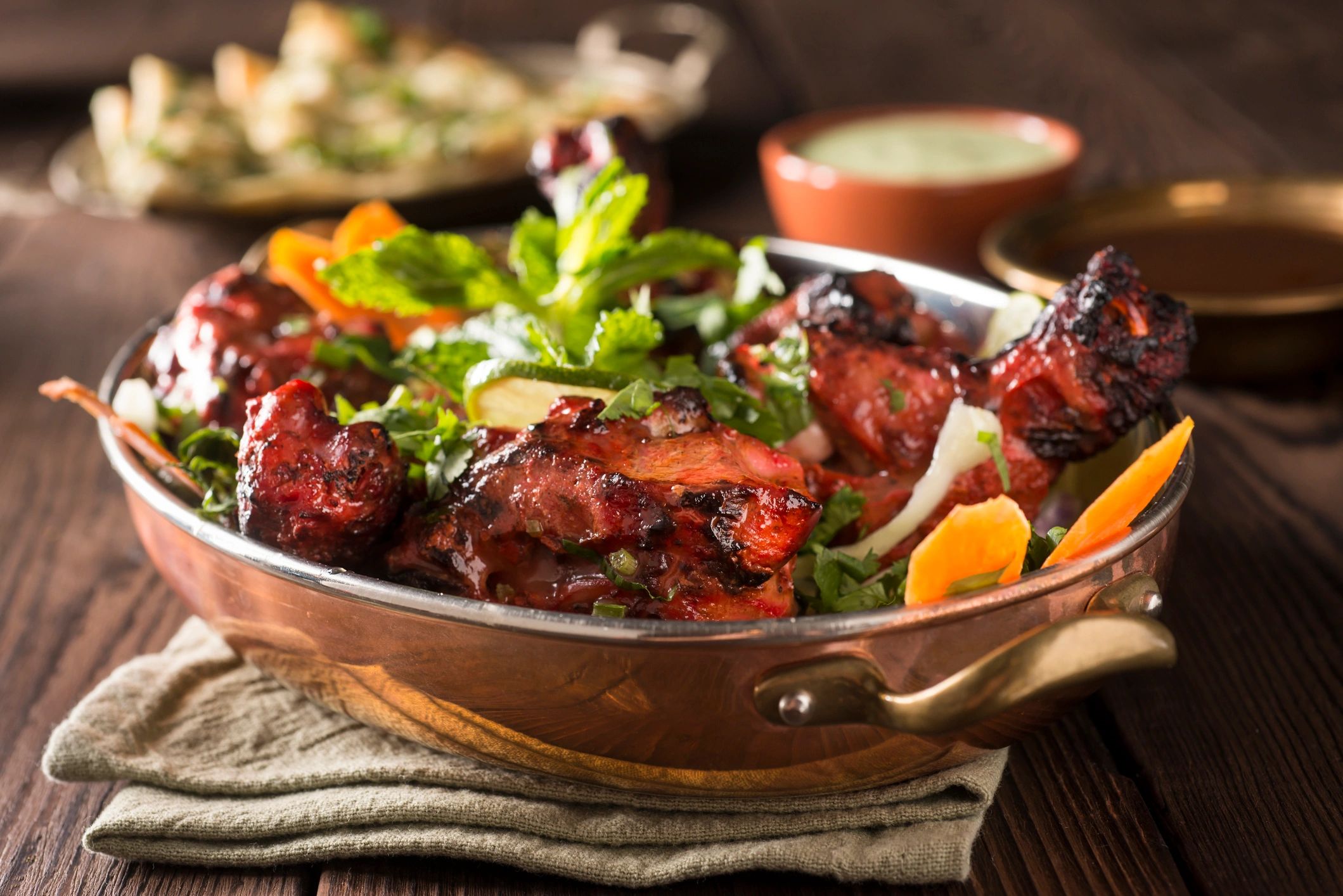 Tandoori chicken served with naan bread on a rustic table